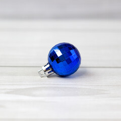 Beautiful blue Christmas ball with pattern on a light wooden background, close up