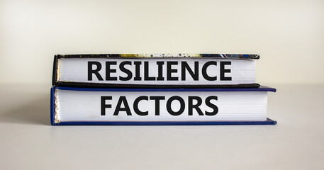 Resilience factors symbol. Books with text 'Resilience factors' on white table. Beautiful white background. Business and resilience factors concept, copy space.
