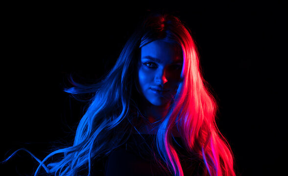 Portrait of fashion young girl in red and blue neon light in the studio.