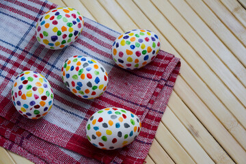 Easter eggs with colorful paint dots. Spring holiday. Easter photo background. Homemade simple painted Easter holiday eggs.