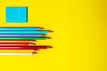 Color pencils, colored blank paper and empty space for text. Children's creative art and education concept. top view.
