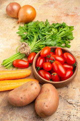 top view cooking ingredients concept with roma tomatoes potatoes onions carrot and a bunch of parsley for salad on a wooden background