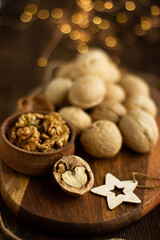 many whole walnuts on a board next to chopped walnuts and walnut kernels on a wooden background