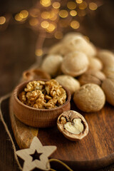 many whole walnuts on a board next to chopped walnuts and walnut kernels on a wooden background