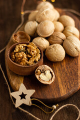 many whole walnuts on a board next to chopped walnuts and walnut kernels on a wooden background