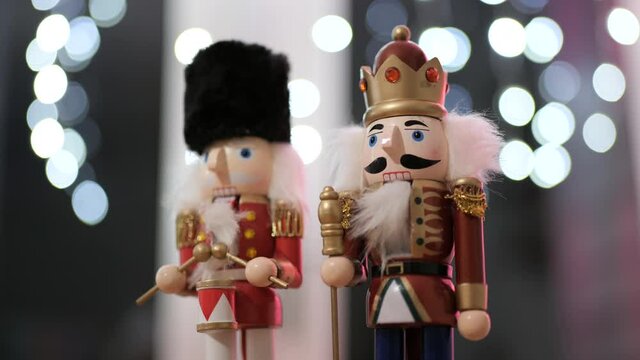 Two Christmas Holidays Nutcrackers next to each other at night with cozy bokeh lights at the background