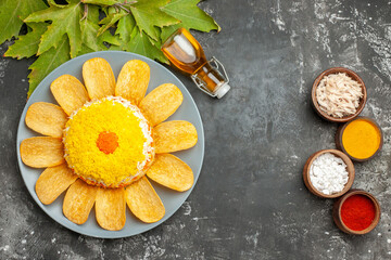 top view of salad with oil bottle and leaves on side with herbs near to it on dark grey table