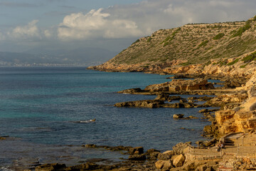 A wonderful calm and relaxed view of the coast shore of Mallorca Island in the mediterranean with blue turquoise sea water on a warm sunny evening at the golden hour