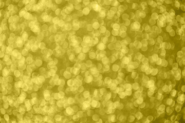 Golden abstract bokeh background. Color of the year 2021. Illuminating background. Christmas textures. Defocused shiny sequins.