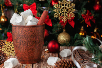 Hot chocolate mug and marshmallows in the background of the Christmas tree