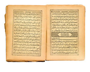 Opened an old Quran on white background