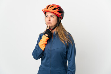 Middle age cyclist woman isolated on white background having doubts while looking up