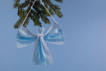 Angel made from face protection mask on blue background. Christmas concept pn pandemic.
