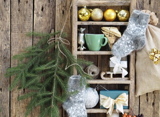 Rustic retro wooden shelf with Christmas decor, a cup of coffee with homemade cookies and spruce branches on a wooden background.Congratulatory background.