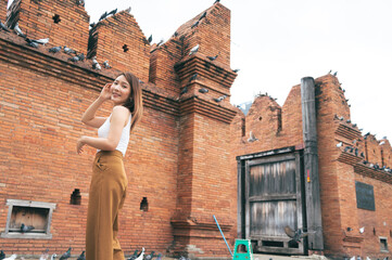 Asian woman traveling at the city wall tha pae gate landmark in Chiang Mai Thailand