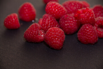 ripe red raspberries on a dark background
