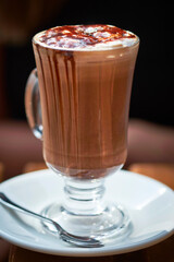 A tall glass with an elegant chocolate mocha coffee drink