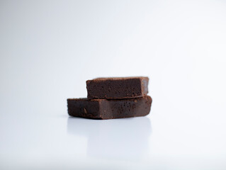 Two slices of brownie on white background