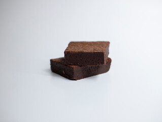 Two slices of brownie on white background