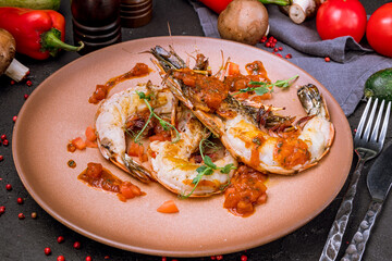 some langoustines on a plate on black concrete