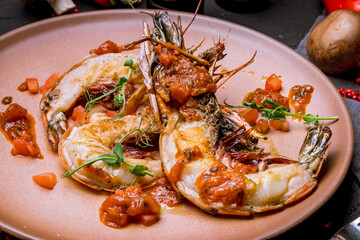 some langoustines on a plate on black concrete