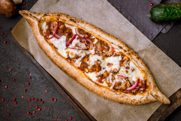 Turkish pide with meat, beans and cheese on the board