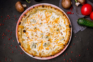 Pizza Quattro formaggi on black stone table top view