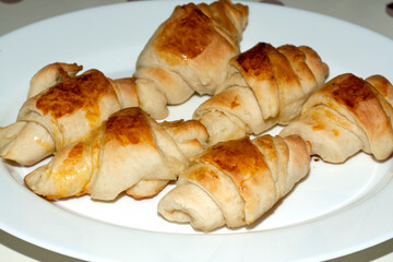 Fresh homemade croissants on white plate
Low angle view