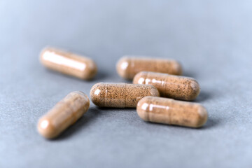 Ashwagandha (Withania somnifera) capsules on paper background. Close up. 