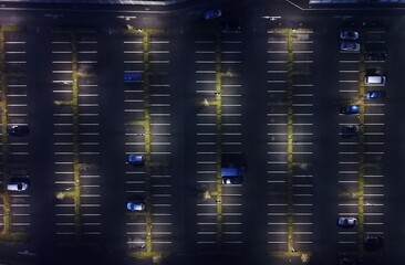 Großer mit Laternen beleuchteter Parkplatz mit wenigen Autos aus der Vogelperspektive