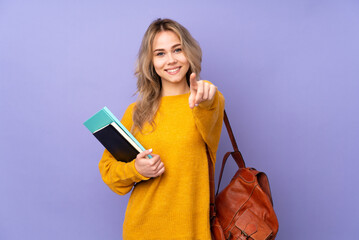 Teenager Russian student girl isolated on purple background making phone gesture and pointing front