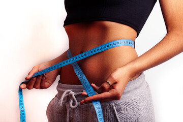 woman measuring waist with tape on knot, african tan isolated