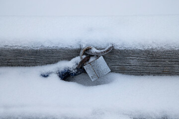 an old frozen lock , silver lock covered with snow 
