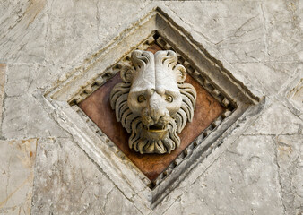 Close-up of a lion's head stonework on the facade of the Baptistery of St John, built between 1316 and 1325 near the Cathedral of Siena, Tuscany, Italy