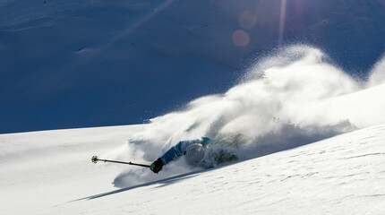 Skier crashing downhill on ski slope in high mountains