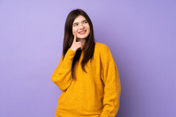 Obraz premium Young Ukrainian teenager girl over isolated purple background thinking an idea while looking up