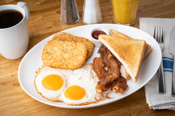 american breakfast with egg, bacon, hash brown and toast