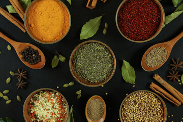 Wide variety spices and herbs on background of black table