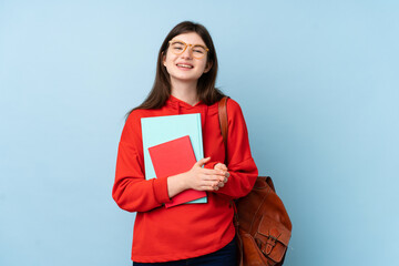 Obraz premium Young Ukrainian teenager student girl holding a salad over isolated blue background applauding