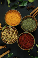 Wide variety spices and herbs on background of black table