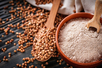 fresh natural buckwheat flour on a dark wooden rustic background culinary concept