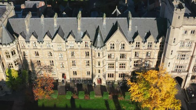 Oxford, United Kingdom. October 2019. Aerial view of old campus' facade. Wonderful building by the green lawn. High quality 4k footage