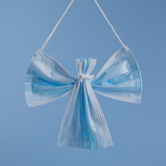 Angel made from face protection mask on blue background. Christmas concept pn pandemic.
