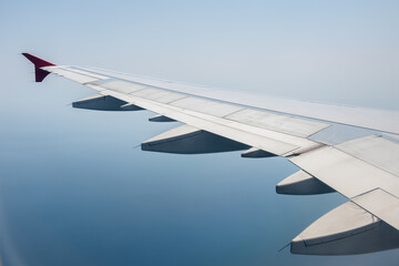 airplane wing with cloudy blue sky