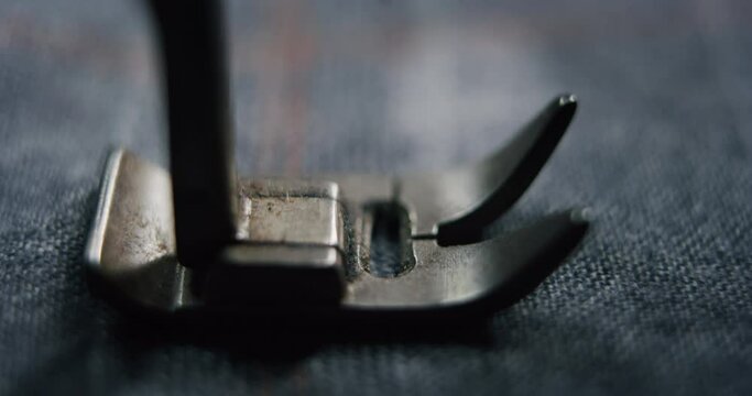 Cinematic macro shot of sewing machine stitching thread on fine quality fabric for creation custom haute couture apparel in traditional tailoring atelier. Concept of handmade, couturier and tradition.