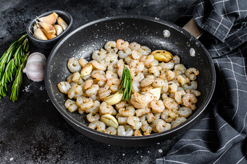 Fried Peeled Shrimps, Prawns in a pan. Black background. top view