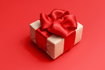 Christmas gift with red ribbon on a red background