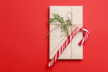 New Year's gift with thuja sprig and candy on red