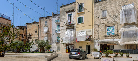 Fototapeta premium improvised sunshades and curtains before windows on the square Piazza degli Innamorati at Bari, Italy