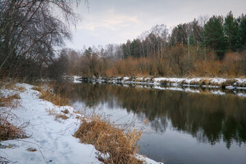 Winter landscape the river in the forest at sunset. Winter sunset rural river landscape.